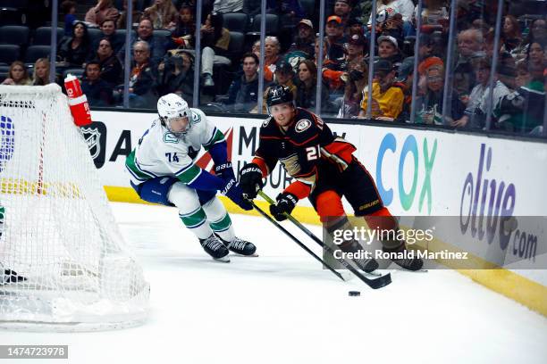 Isac Lundestrom of the Anaheim Ducks skates the puck against Ethan Bear of the Vancouver Canucks in the second period at Honda Center on March 19,...