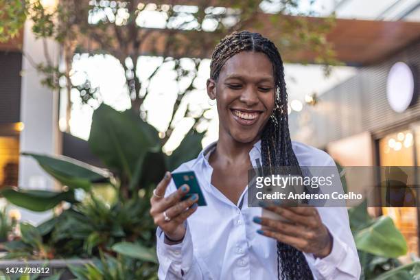 black woman shopping online in a public place - black transgender 個照片及圖片檔