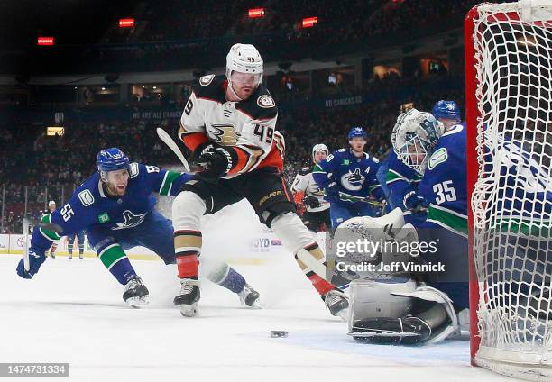 Guillaume Brisebois of the Vancouver Canucks looks on as Thatcher Demko of the Vancouver Canucks makes a save on Max Jones of the Anaheim Ducks...