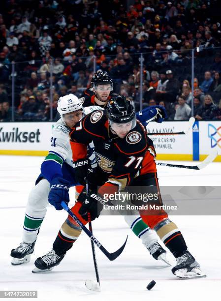 Frank Vatrano of the Anaheim Ducks skates the puck against Dakota Joshua of the Vancouver Canucks in the third period at Honda Center on March 19,...
