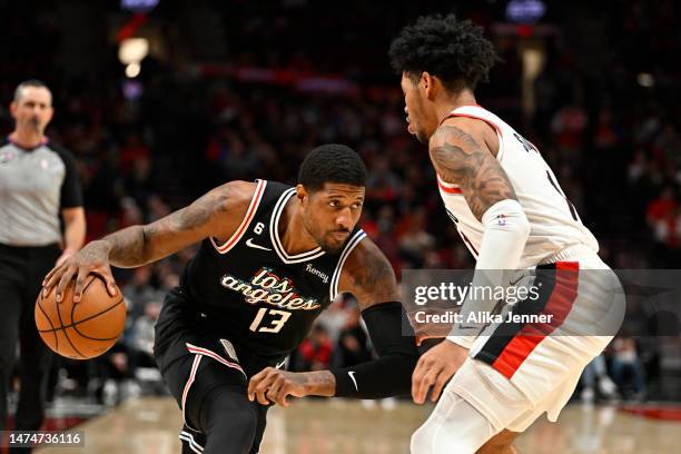 Paul George of the LA Clippers dribbles against Anfernee Simons of the Portland Trail Blazers during the second quarter at the Moda Center on March...