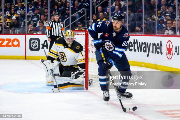 Nino Niederreiter of the Winnipeg Jets plays the puck as goaltender Jeremy Swayman of the Boston Bruins keeps watch during first period action at the...