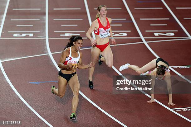 Nevin Yanit of Turkey crosses the line to win gold ahead of Beate Schrott of Austria and Alina Talay of Belarus in the Women's 100 Metres Hurdles...