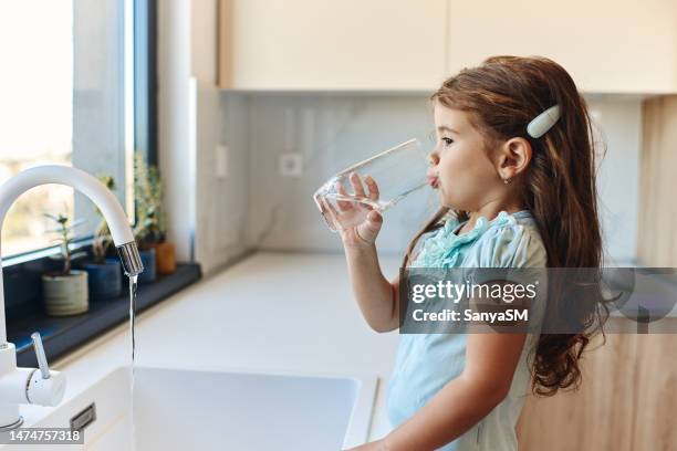 hermosa chica beber agua - niño-tomando-agua fotografías e imágenes de stock