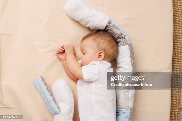 happy baby sleeping, lying down on side. - pillow stock pictures, royalty-free photos & images