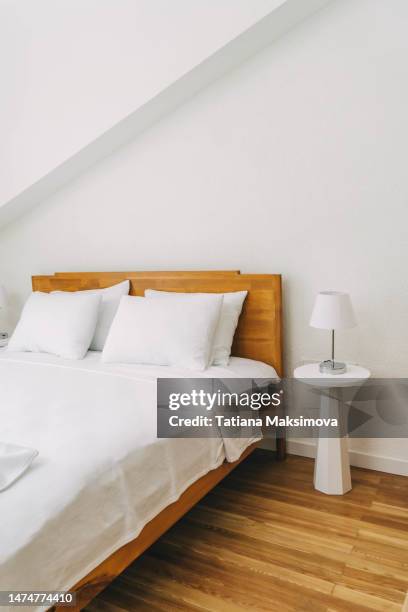 an empty hotel room, a view of a freshly made white bed. - design bedroom stock-fotos und bilder