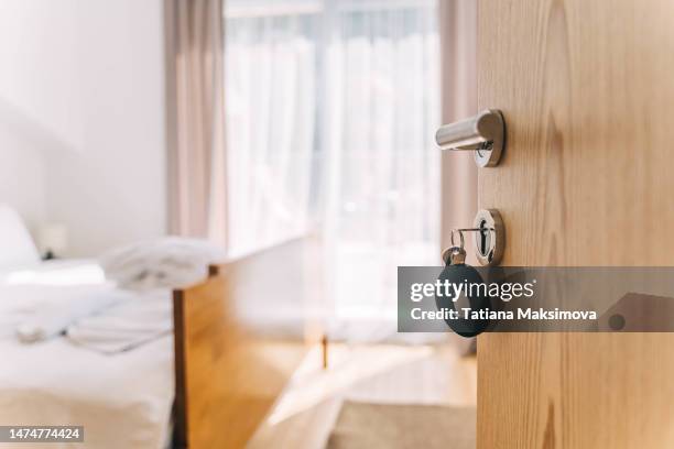 an empty hotel room, a view of a freshly made white bed. - blurry living room stockfoto's en -beelden