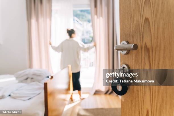 an empty hotel room, a view of a freshly made white bed. - luxury hotel door stock pictures, royalty-free photos & images