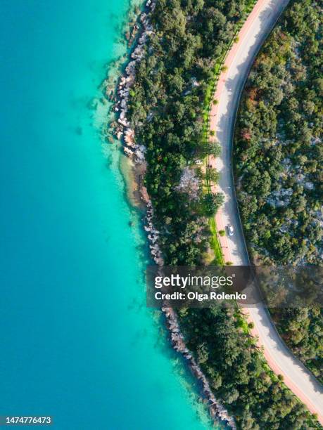 natural road curve with car, surrounded by green tree area near the turquoise seashore in kas, turkey - antalya province stock pictures, royalty-free photos & images