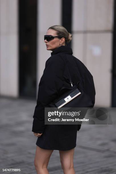 Kathrin Bommann seen wearing Chimi black sunglasses, gold earrings, Adanola cropped black puffer jacket, Vival Studio grey pinstripes mini skirt,...