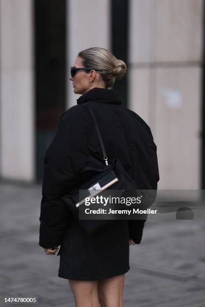 Kathrin Bommann seen wearing Chimi black sunglasses, gold earrings, Adanola cropped black puffer jacket, Vival Studio grey pinstripes mini skirt,...