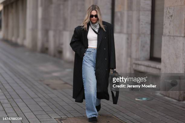 Kathrin Bommann seen wearing Saint Laurent black sunglasses, Hermès black and white bandana, Magda Butrym pinstripes black grey long coat, Raey wide...