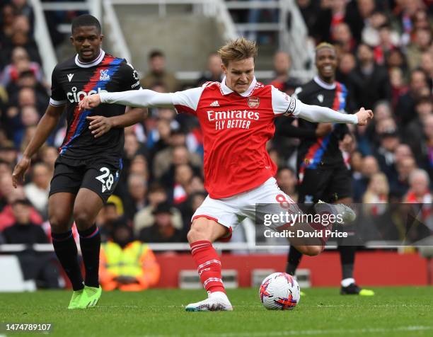 Martin Odegaard of Arsenal shoots under pressure from Cheick Oumar Doucoure of Palace during the Premier League match between Arsenal FC and Crystal...