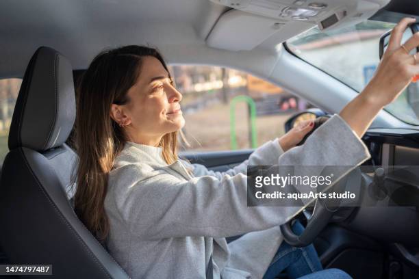 adjusting the rearview mirror - mirrors while driving stock pictures, royalty-free photos & images