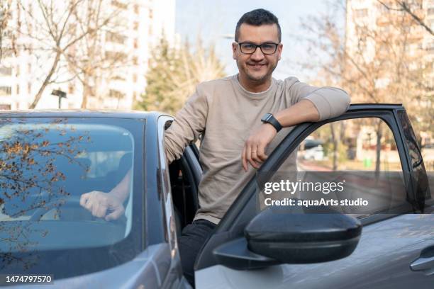 man leaning on car door - naast stockfoto's en -beelden