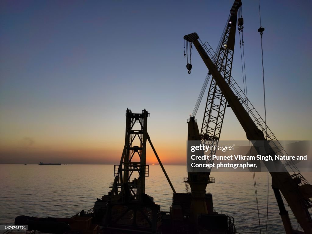 Offshore Construction cranes in the backdrop of sunset