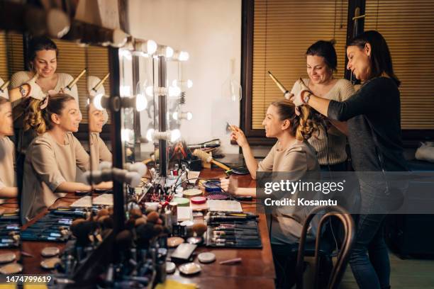 hairdressers make beautiful curls with a curler on the hair of a theater actress - backstage mirror stock pictures, royalty-free photos & images