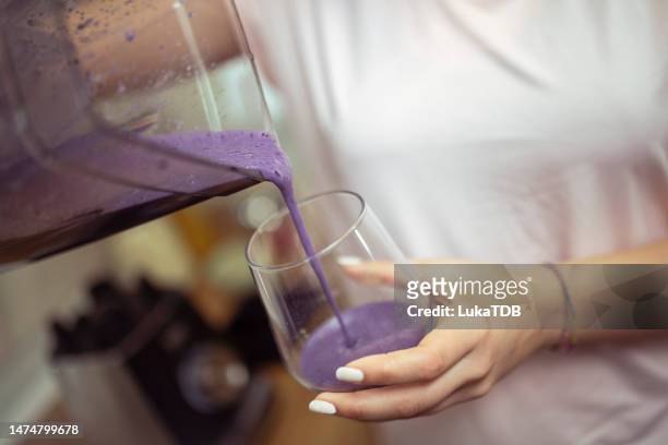 nahaufnahme von weiblichen händen, die smoothie in trinkglas gießen - smoothie close up textfreiraum stock-fotos und bilder