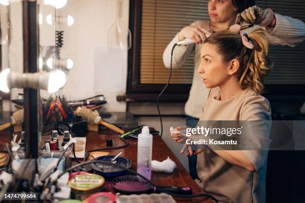 actress removes the nail polish using nail polish remover and cotton wool, while the hairdresser does her hair - theatre dressing room stock pictures, royalty-free photos & images