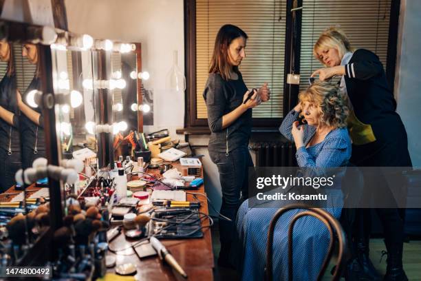 el maquillador y el peluquero preparan a la actriz para la actuación - vestuario entre bastidores fotografías e imágenes de stock