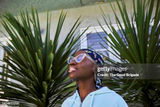 female cancer survivor standing outside on sunny day - resilienza foto e immagini stock