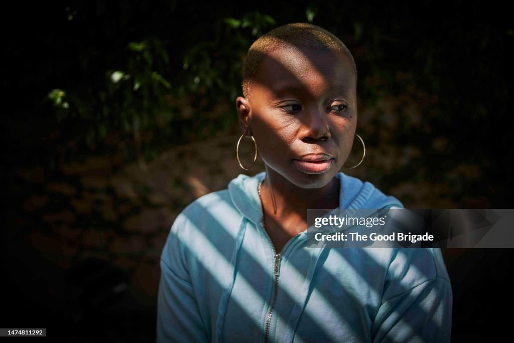 Thoughtful portrait of cancer survivor outside on sunny day