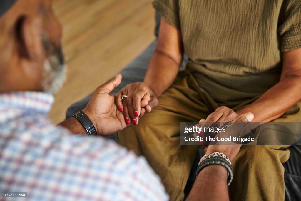High angle view of mother and adult son holding hands