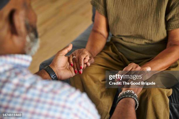 high angle view of mother and adult son holding hands - apoio emocional imagens e fotografias de stock