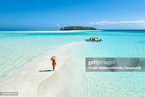 woman walking on idyllic beach in the middle of the ocean - ilha de zanzibar imagens e fotografias de stock