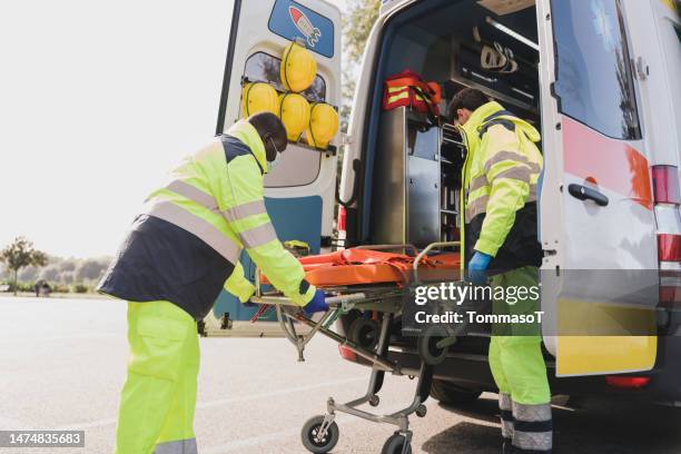 2 paramédicos descargando la camilla - vehículo de emergencia fotografías e imágenes de stock