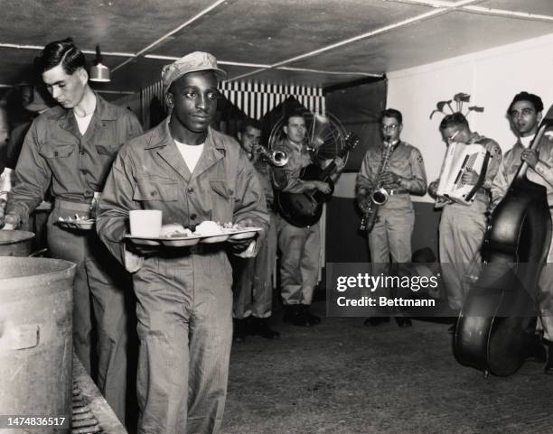 An American soldier named as Private James Gatlin from Chicod, North Carolina, carries a tray of food as he awaits repatriation to the United States...