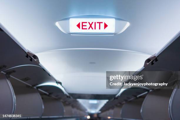 emergency exit sign on ceiling inside passenger aircraft cabin - 非常口 ストックフォトと画像