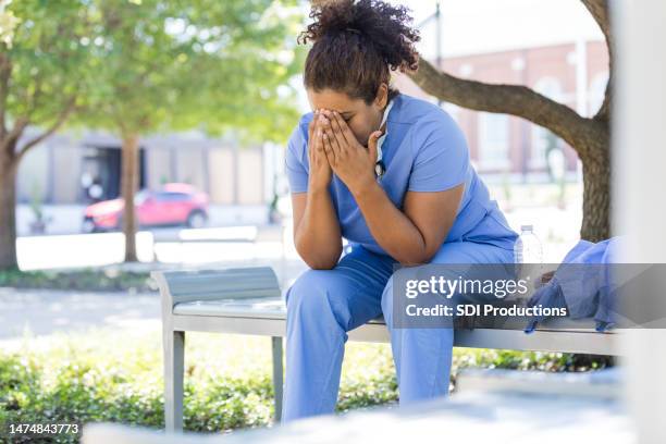 emotionally distressed female medical professional puts head in hands - nurse praying stock pictures, royalty-free photos & images