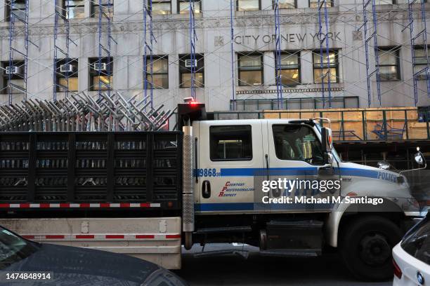 An NYPD truck carries metal barricades en route to Manhattan Criminal Court on March 20, 2023 in New York City. The barricades were set up as Michael...