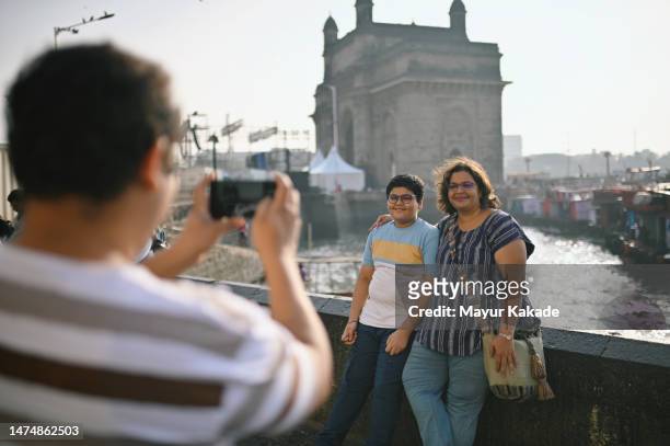 father taking a photo of his wife and cute - india tourism stockfoto's en -beelden