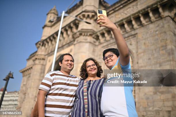 family clicking selfie standing near the gateway of india, mumbai - father clicking selfie stock pictures, royalty-free photos & images