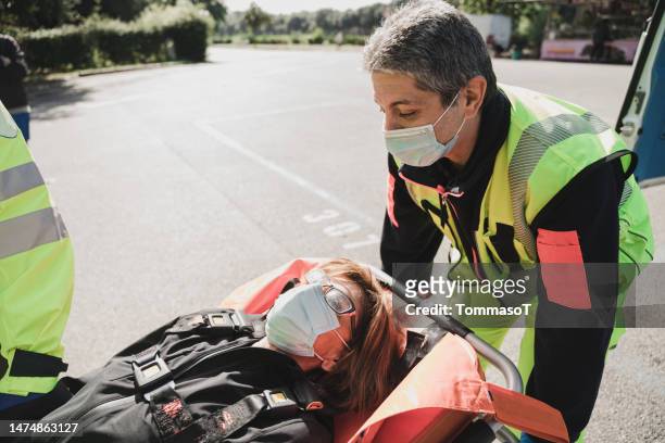 patient carried by two rescuers after accident - medical symbol stock pictures, royalty-free photos & images