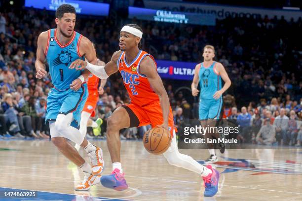 Shai Gilgeous-Alexander of the Oklahoma City Thunder drives past Devin Booker of the Phoenix Suns during the third quarter at Paycom Center on March...