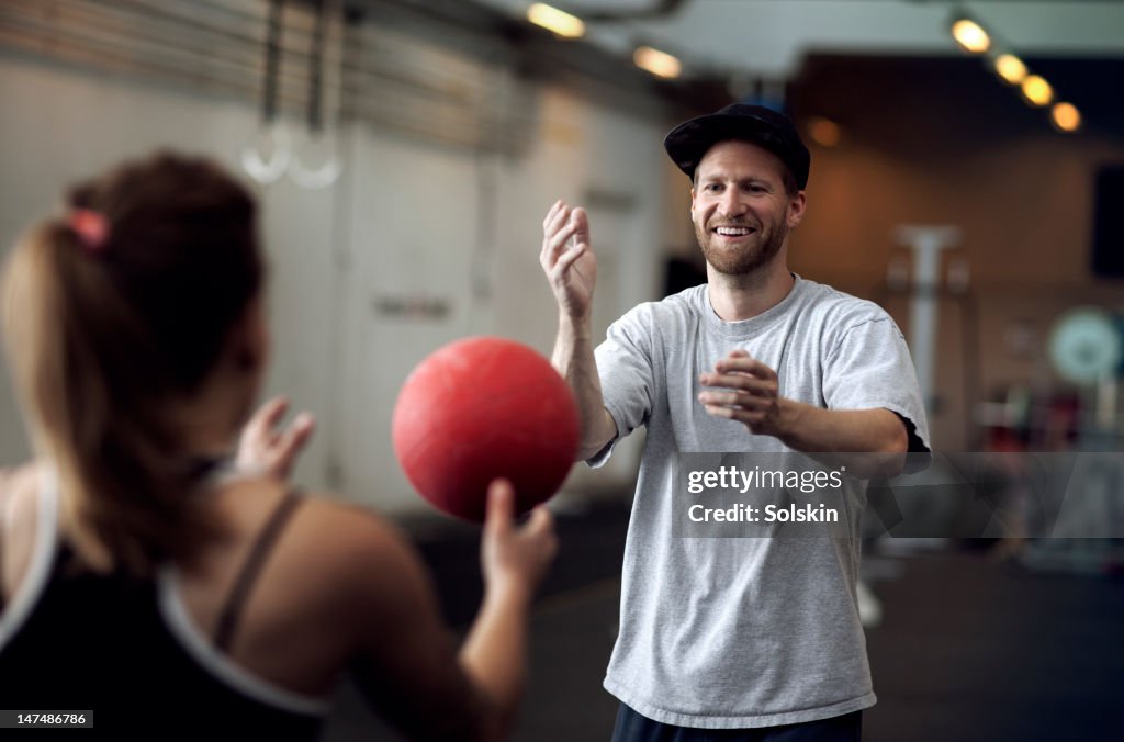 Man and woman training with ball at gym