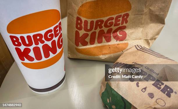 In this photo illustration, a man eats a Whopper Meal at branch of the fast food restaurant Burger King, on March 19, 2023 in Fleet, England. Founded...