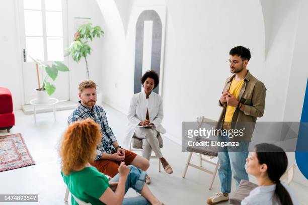 multiracial people participating in group therapy at mental health center - irrational fear stock pictures, royalty-free photos & images