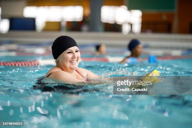 woman in the pool doing aqua-aerobics - water aerobics stock pictures, royalty-free photos & images
