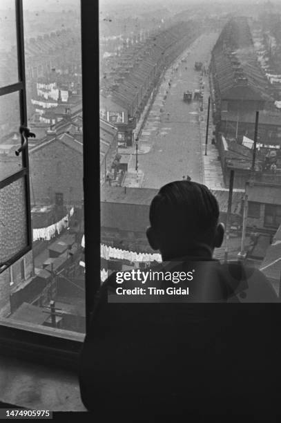 Resident looks out the window of the Flying Angel, a Missions to Seamen hostel on Victoria Dock Road in London, circa 1940. Original Publication :...