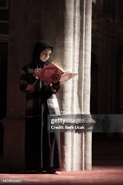 jeune femme musulmane lisant le coran à l’intérieur de la mosquée. - coran photos et images de collection