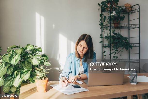 top view close up woman calculating bills, money, loan or rent payments, using laptop, online banking service, sitting at table, female holding receipt, planning budget, managing expenses, finances - gesetzentwurf stock-fotos und bilder
