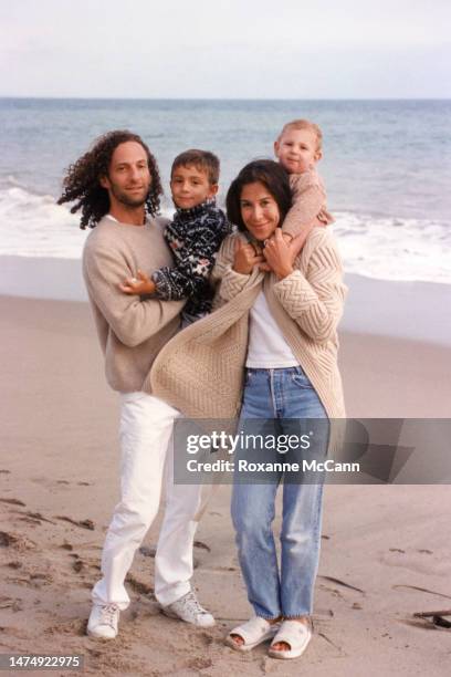 Saxophonist Kenny G holds his son Max Gorelick while walking with his wife Lyndie Benson who is holding their son Noah Gorelick on the beach in 1998...