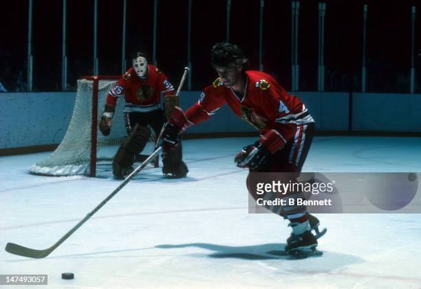 Bobby Orr of the Chicago Blackhawks skates with the puck as goalie Tony Esposito looks on during their NHL game circa 1979.