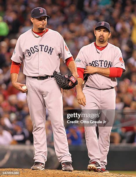 Starting pitcher Josh Beckett of the Boston Red Sox pauses on the mound for a coaching visit after giving up an RBI double to John Jaso of the...