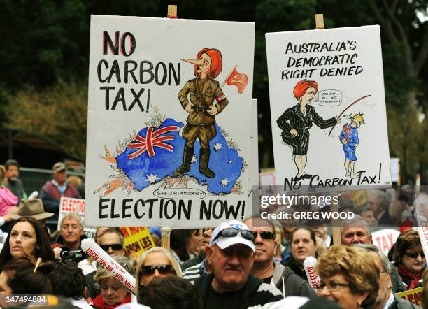 Protesters hold placards as they attend a no carbon tax rally in Sydney on July 1, 2012. Australia on July 1 introduced a controversial carbon tax in...