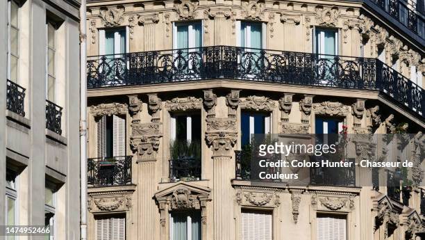 beautiful stone facade of a hausmanian style apartment building in paris, france - paris balcony stock pictures, royalty-free photos & images